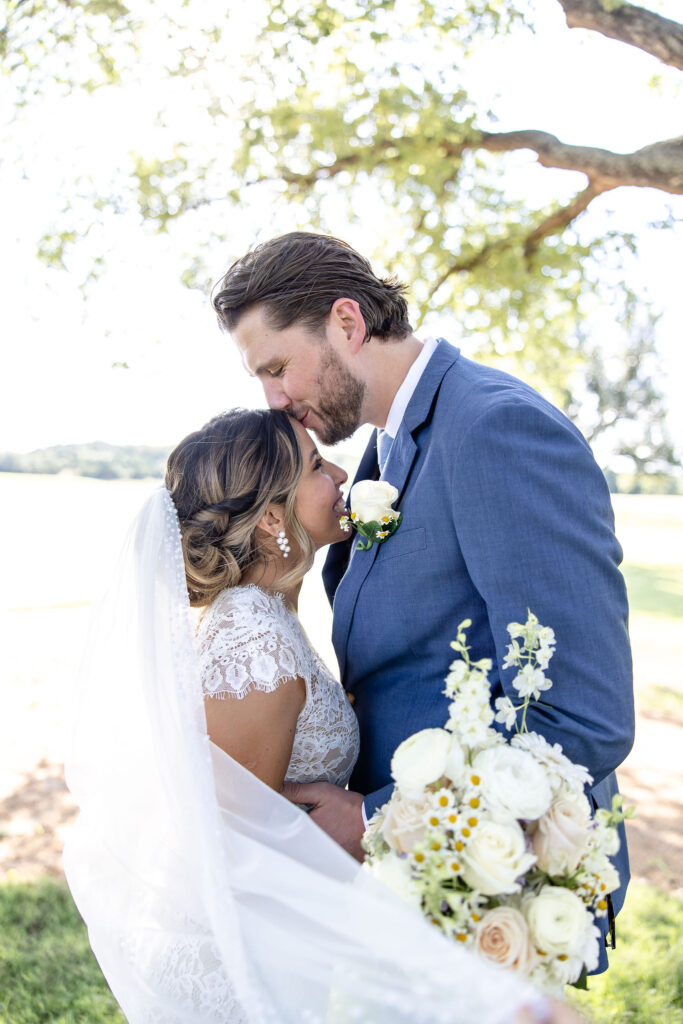 The Vincent Homestead wedding venue in Temple, Texas featuring a lakeside ceremony space surrounded by rolling hills and mature trees.