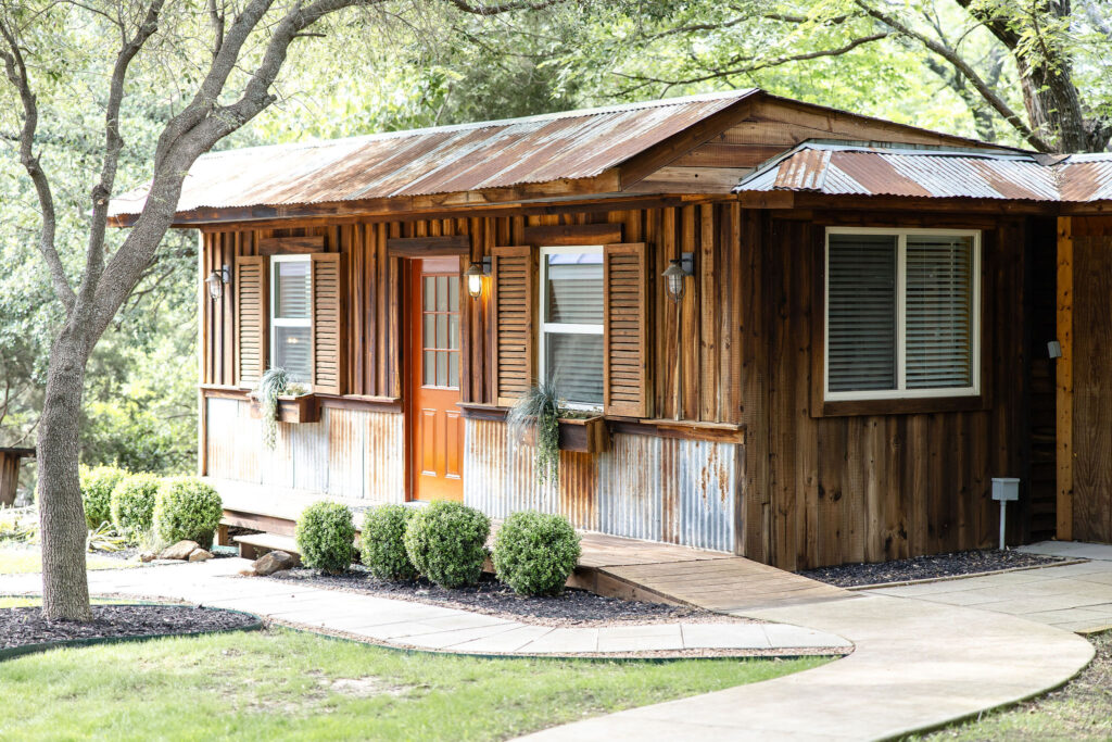 Outdoor wedding ceremony at Trickle Creek Ranch in Weatherford, Texas featuring a stone aisle, mature live oak trees, and a romantic natural setting.