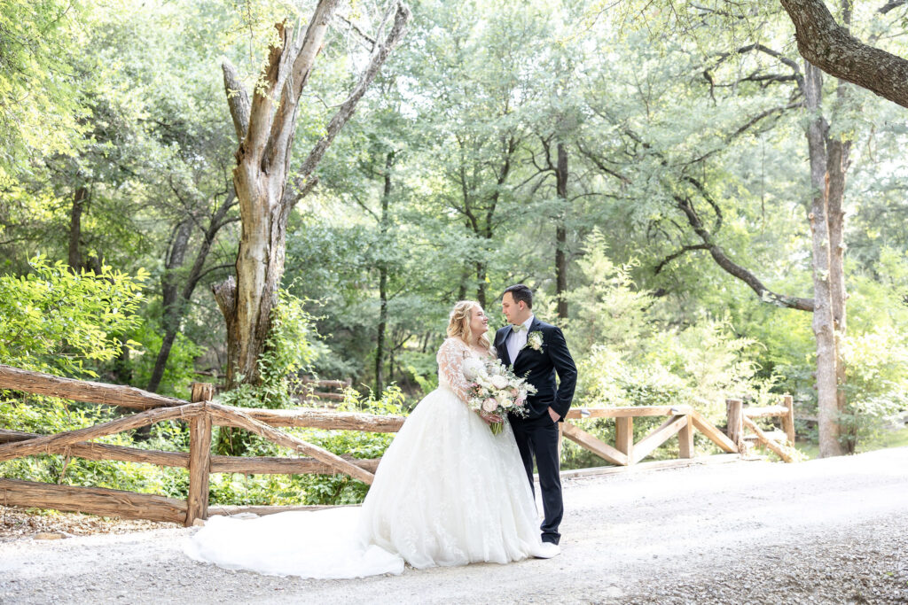 Scenic wedding portraits at Trickle Creek Ranch showcasing the property's spring-fed creek, towering oak trees, and beautiful Texas landscape.